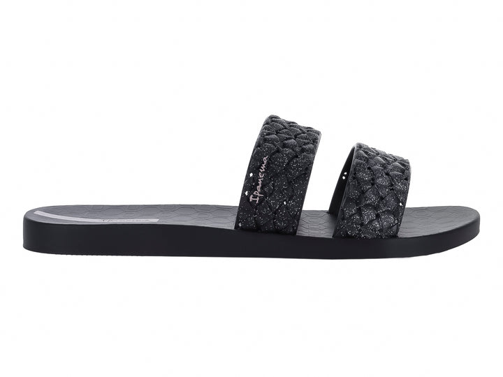 Sandalias negras de la marca Ipanema con tiras anchas texturizadas y suela plana.