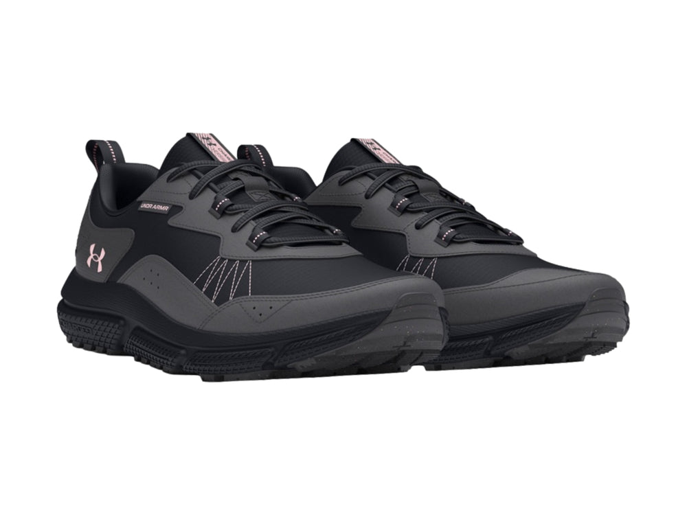 Tenis deportivos Under Armour en color negro y gris oscuro con detalles de costura rosa y suela robusta.