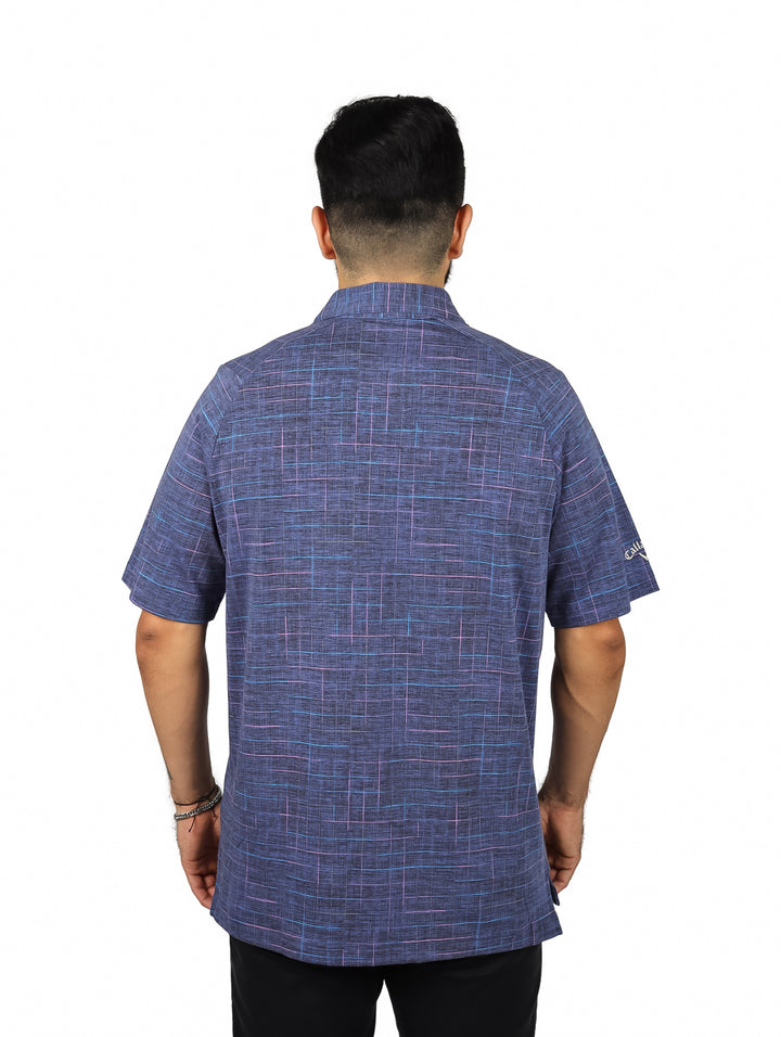 Hombre vistiendo una camiseta polo de golf color azul marino con patrón de cuadrícula y manga corta.