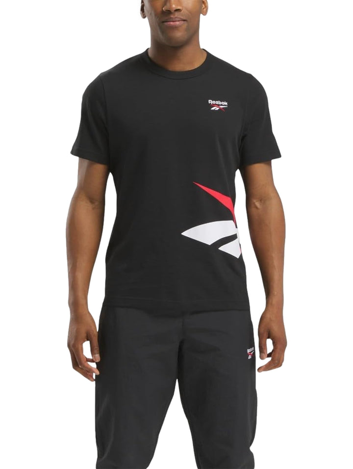 Hombre vistiendo una camiseta deportiva negra de manga corta con logotipo de Reebok.