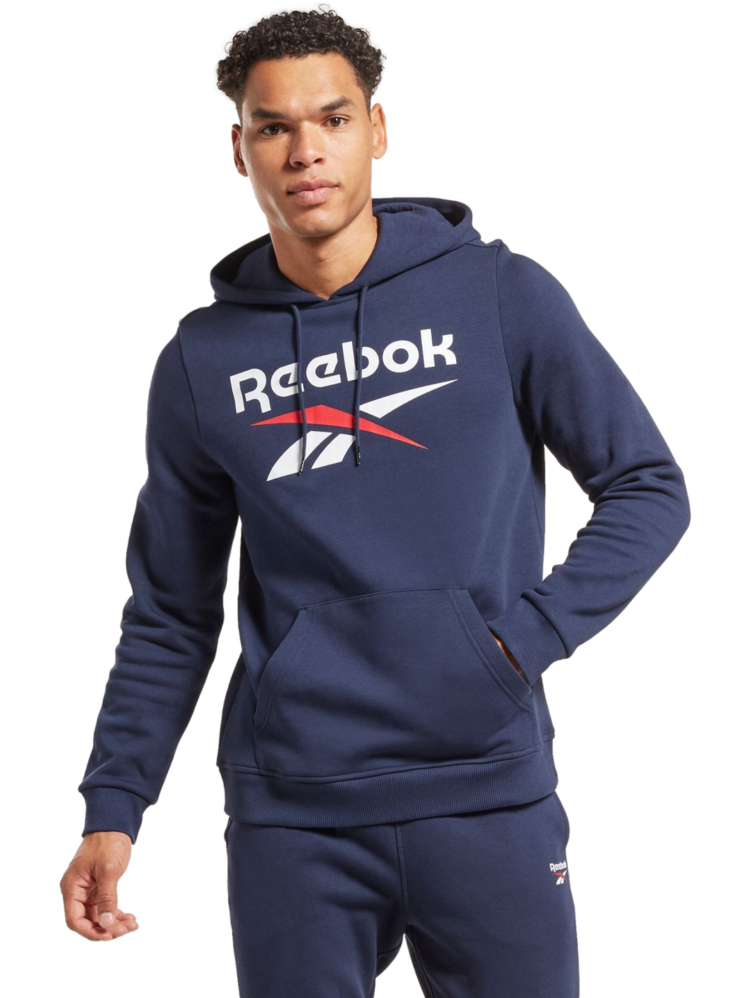 Hombre vistiendo sudadera con capucha azul marino de Reebok con logotipo grande en el pecho.
