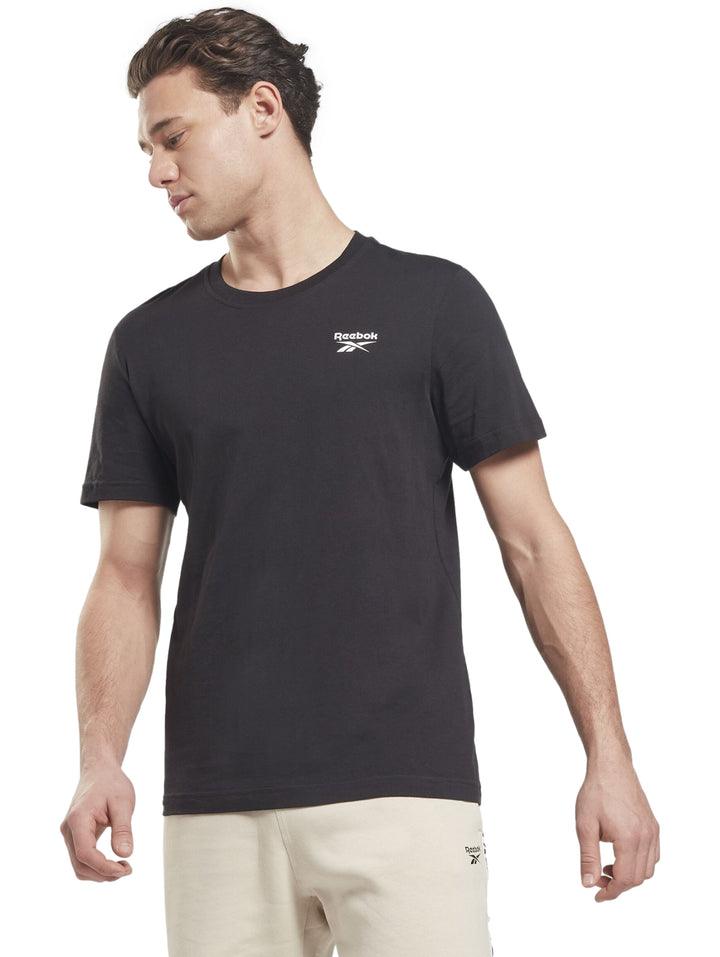 Hombre vistiendo una playera Reebok de color negro con un logotipo pequeño en el pecho.