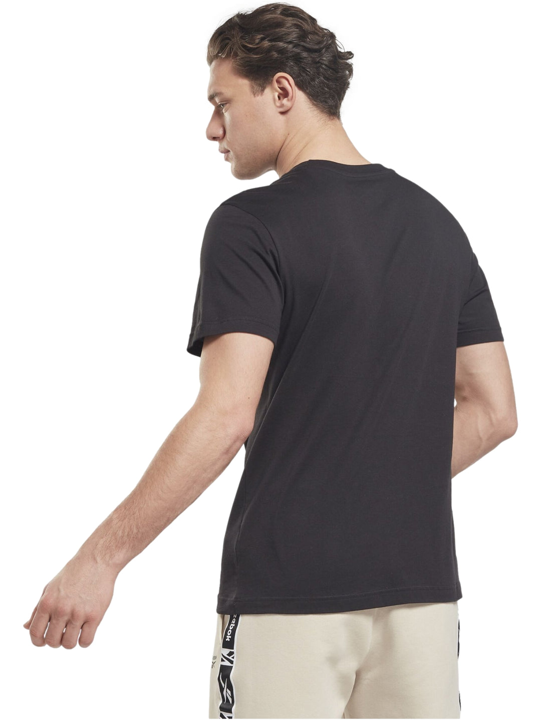 Hombre vistiendo una playera Reebok de color negro con un logotipo pequeño en el pecho.