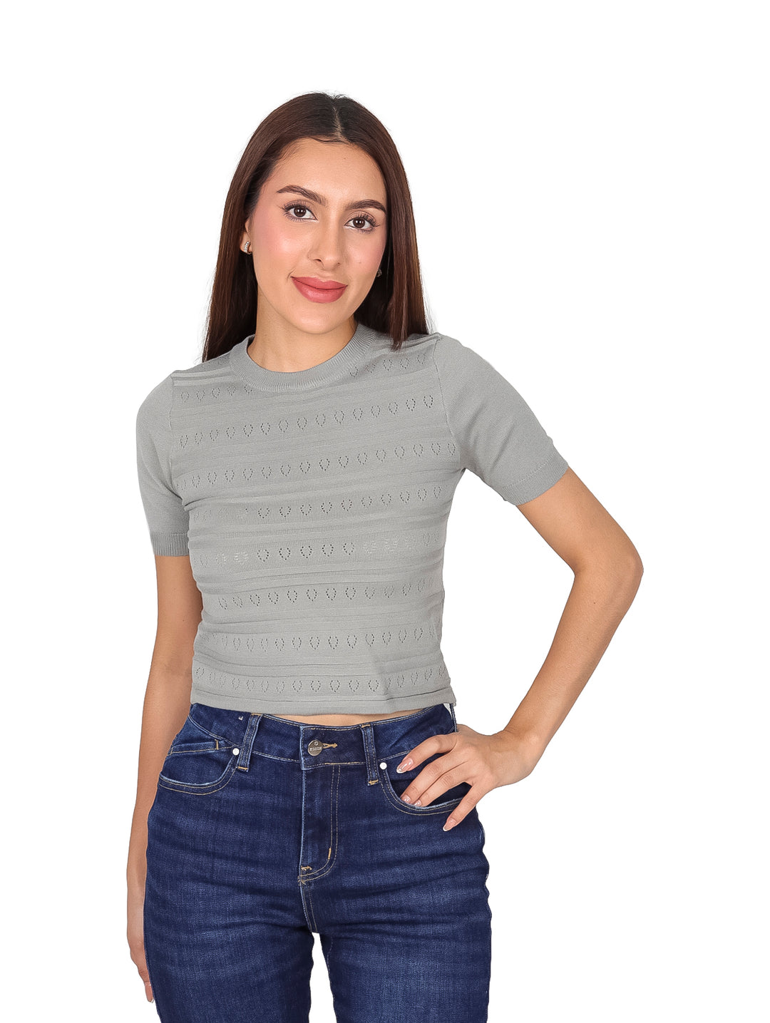 Mujer vistiendo una blusa gris de manga corta con tejido texturizado y jeans azules.