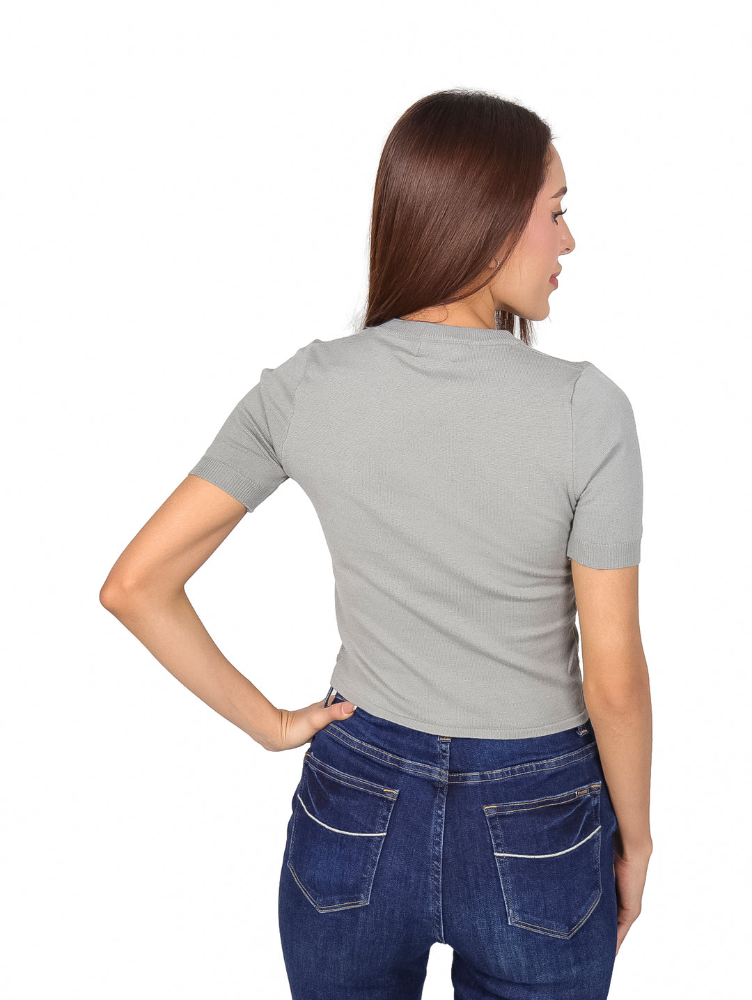 Mujer vistiendo una blusa gris de manga corta con tejido texturizado y jeans azules.