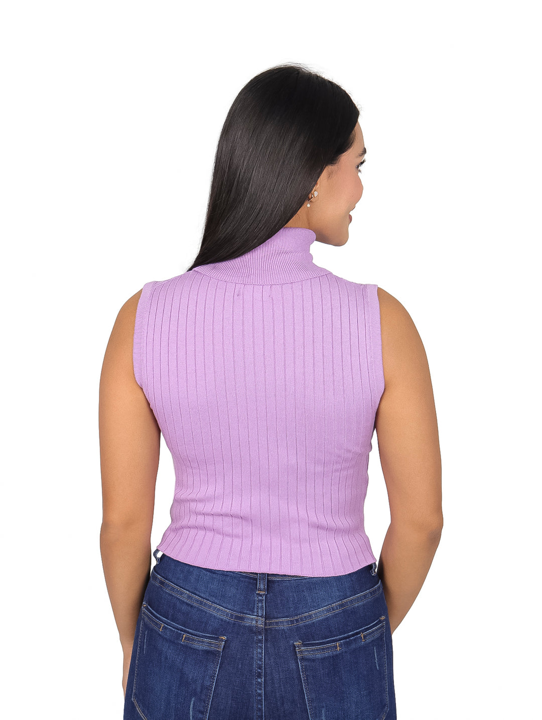 Mujer vistiendo blusa morada sin mangas con cuello tortuga y pantalones de mezclilla.