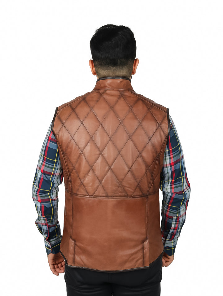 Hombre vistiendo un chaleco de cuero marrón con diseño acolchado en forma de diamante y cierre frontal.