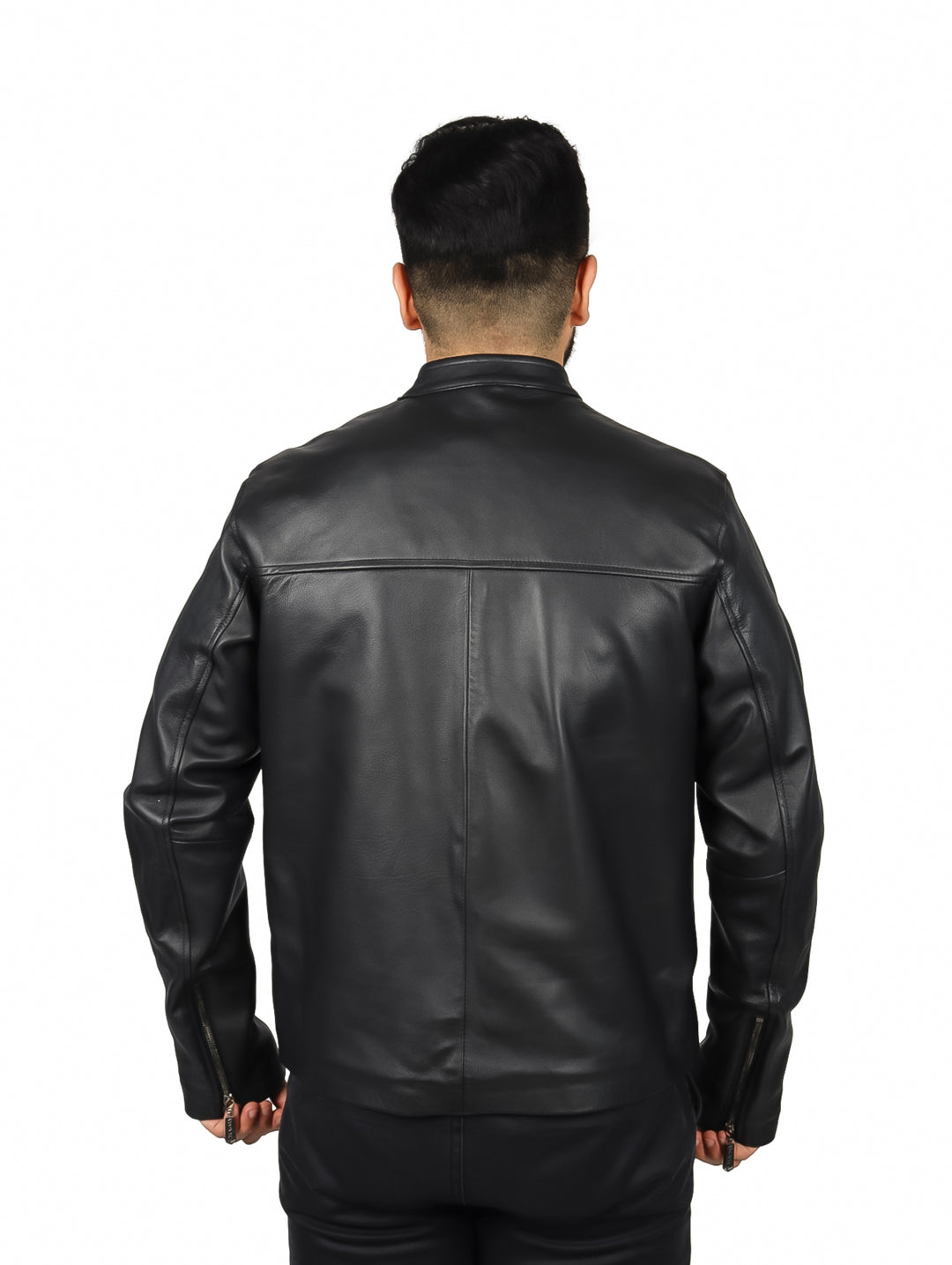 Hombre vistiendo una chaqueta de cuero negra de la marca Cuadra sobre una camisa a cuadros.
