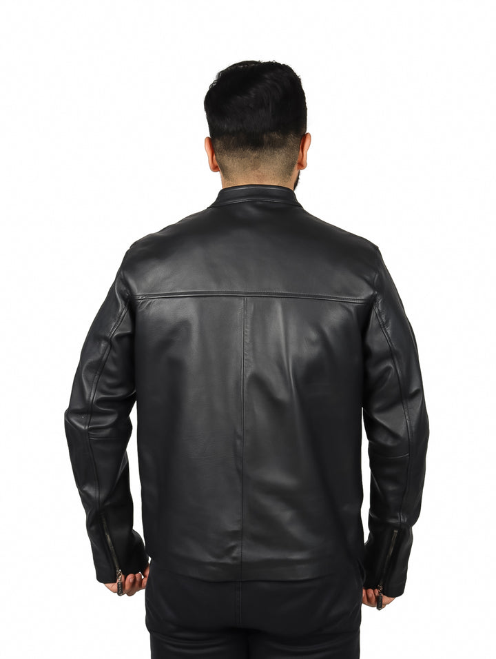 Hombre vistiendo una chaqueta de cuero negra de la marca Cuadra sobre una camisa a cuadros.