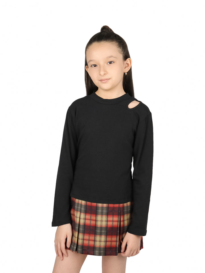 Niña vistiendo blusa negra de manga larga con detalle de abertura en el hombro y falda a cuadros.
