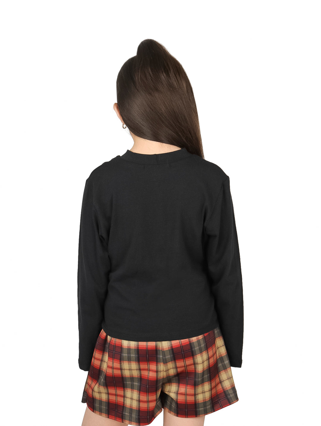 Niña vistiendo blusa negra de manga larga con detalle de abertura en el hombro y falda a cuadros.