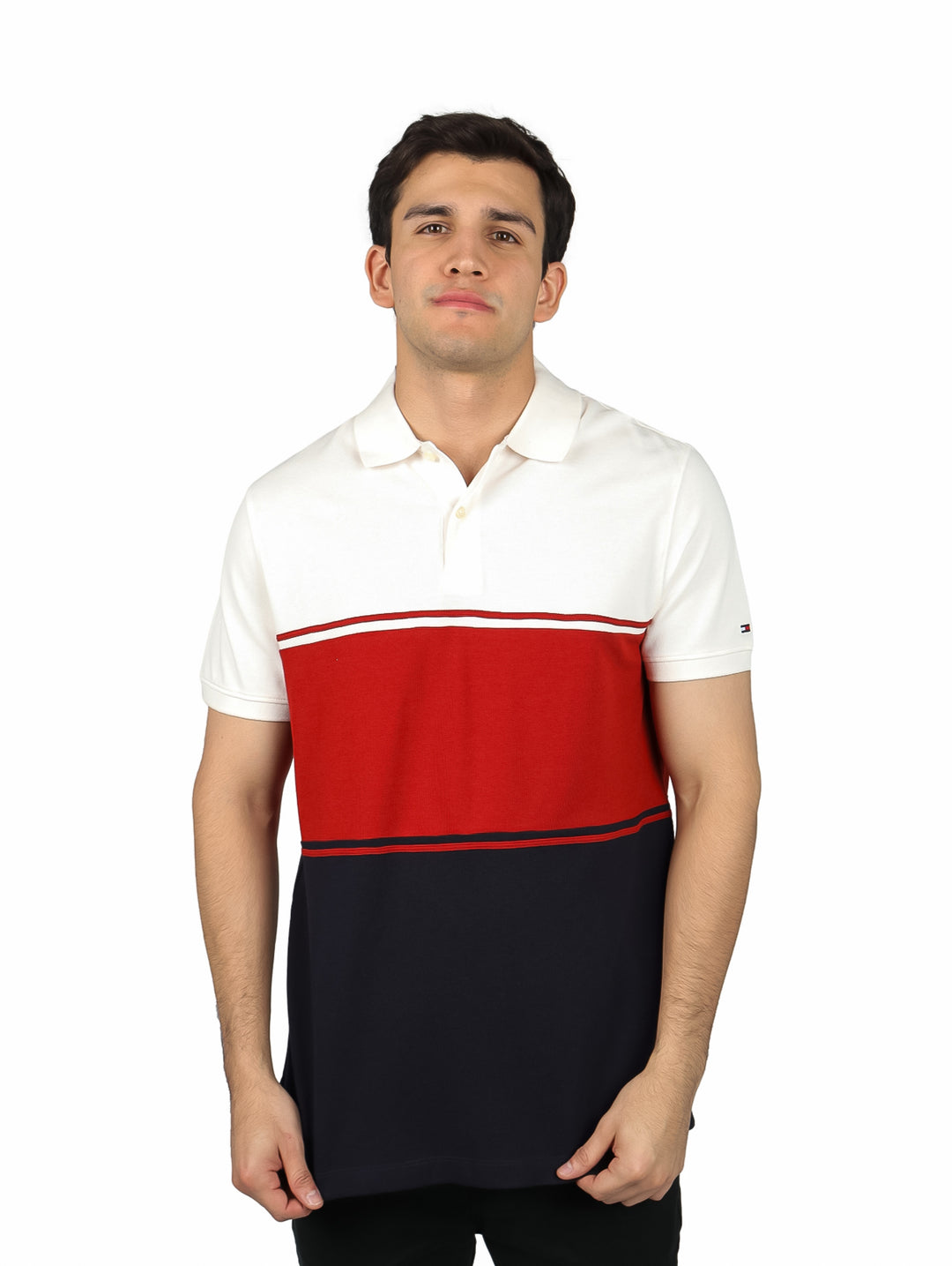 Hombre vistiendo polo Tommy Hilfiger con bloques de color blanco, rojo y azul marino.