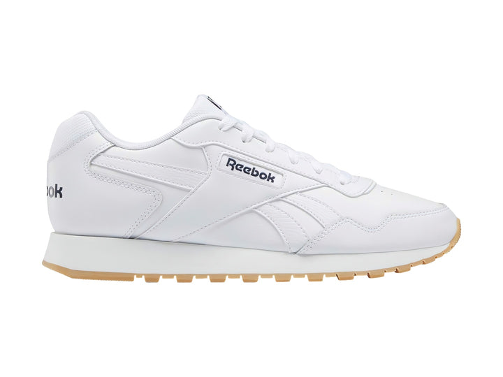 Tenis Reebok Glide en color blanco con suela de goma color café claro.