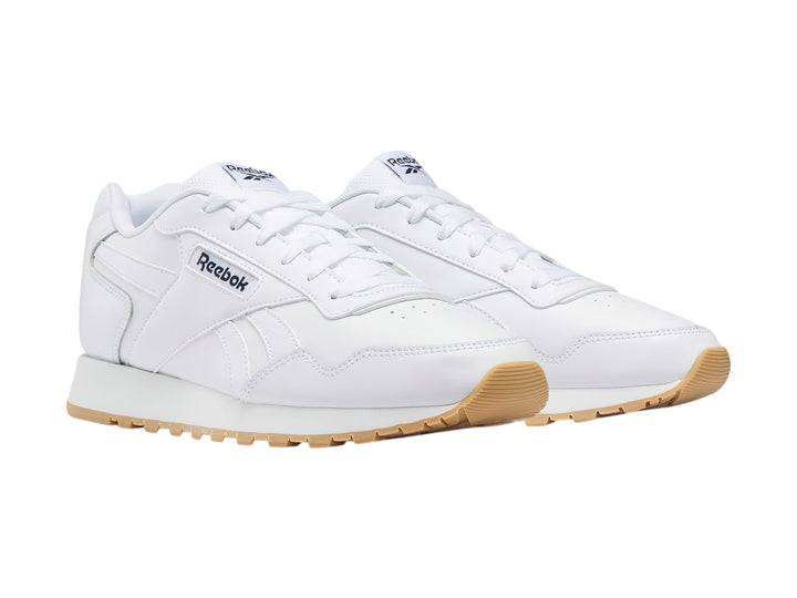 Tenis Reebok Glide en color blanco con suela de goma color café claro.