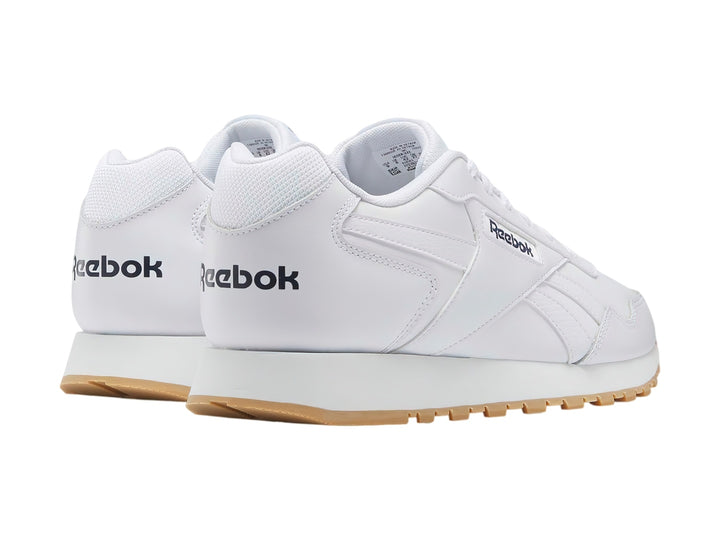 Tenis Reebok Glide en color blanco con suela de goma color café claro.