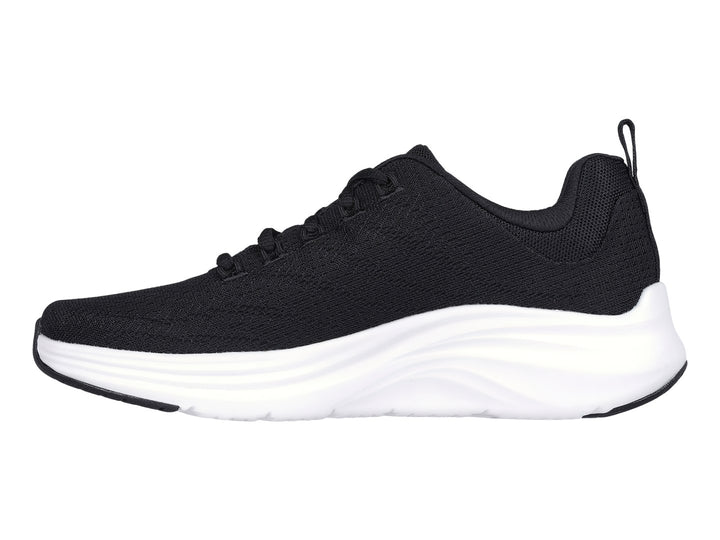 Tenis deportivos Skechers color negro con suela blanca y logotipo lateral en color plata.