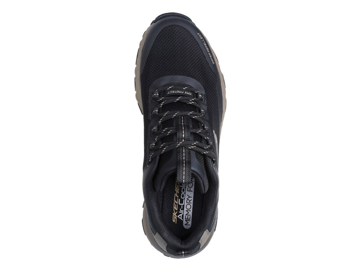 Tenis deportivos Skechers Max Protect en colores negro y beige con suela Goodyear y acabado repelente al agua.