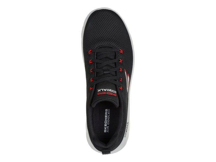 Tenis deportivos Skechers color negro con suela blanca y detalles en rojo.
