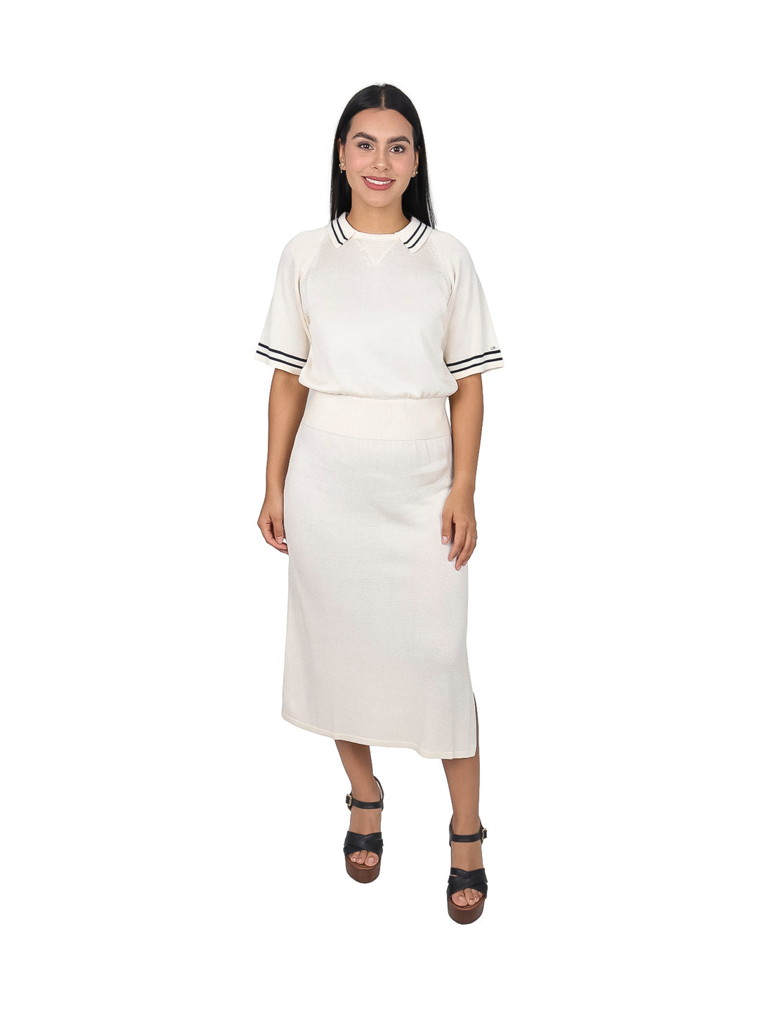 Mujer vistiendo un vestido polo midi color blanco hueso con detalles negros en las mangas.