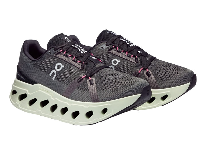 Tenis deportivos On Cloud en color gris con suela gruesa en tono verde lima y detalles en rosa.