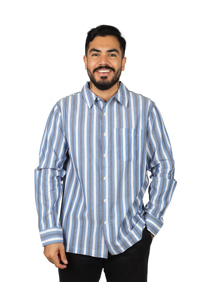 Hombre vistiendo una camisa de manga larga con rayas verticales azules y blancas.