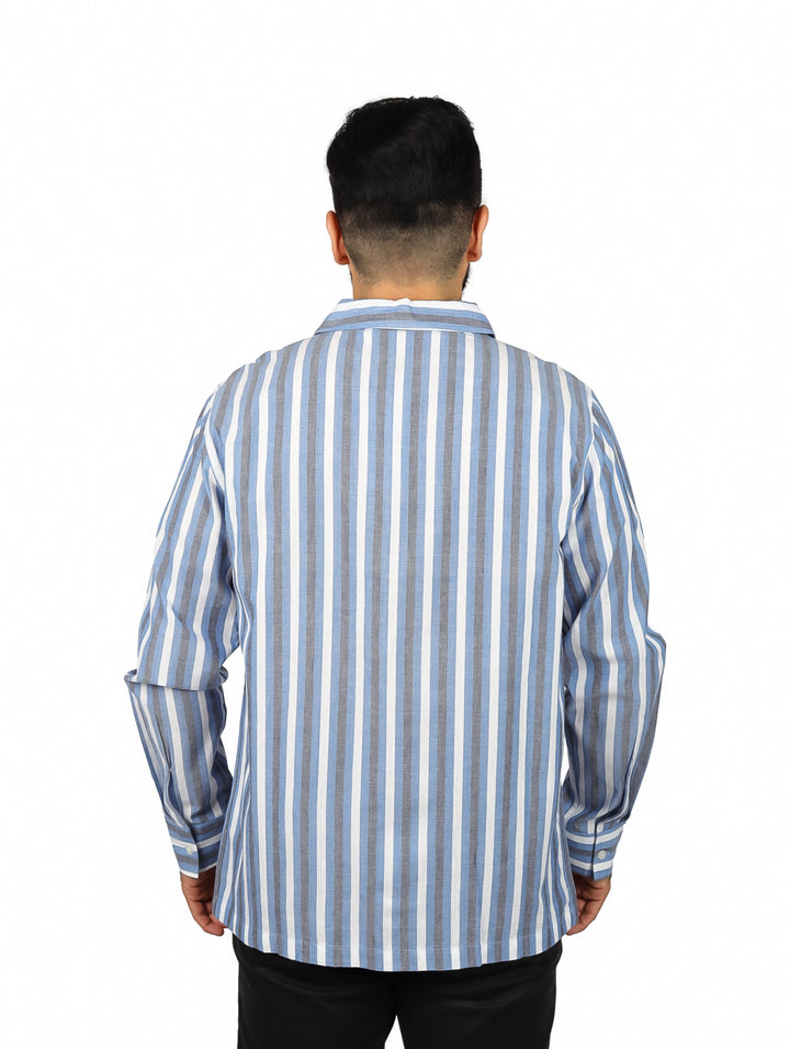 Hombre vistiendo una camisa de manga larga con rayas verticales azules y blancas.