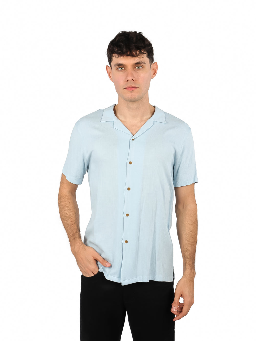 Hombre vistiendo una camisa de manga corta color azul cielo y pantalones negros sobre fondo blanco.