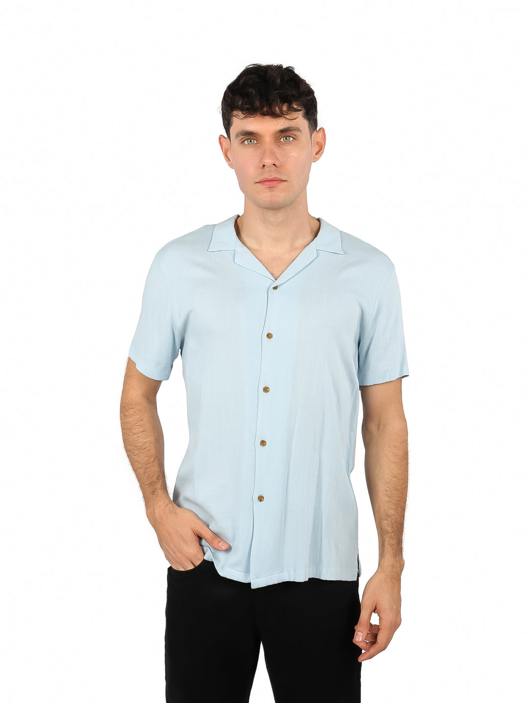 Hombre vistiendo una camisa de manga corta color azul cielo y pantalones negros sobre fondo blanco.