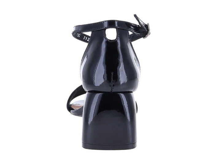 Sandalia negra de charol con tacón cuadrado, correa al tobillo y detalles perforados en la parte frontal.