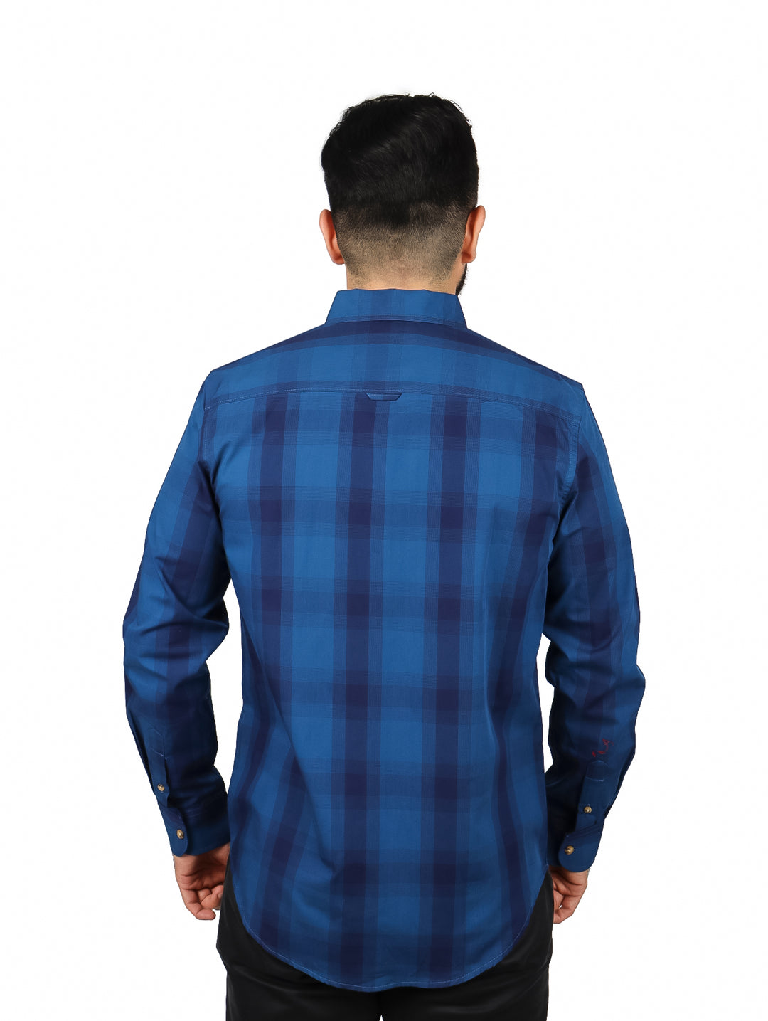 Hombre vistiendo una camisa de manga larga color azul con estampado de cuadros y botones frontales.