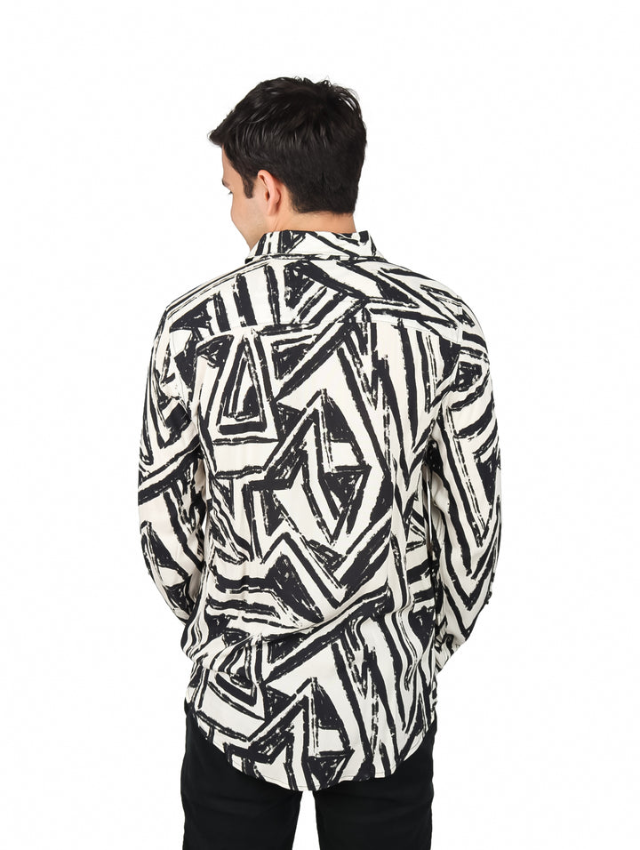 Hombre vistiendo camisa de manga larga color crudo con estampado geométrico en negro.
