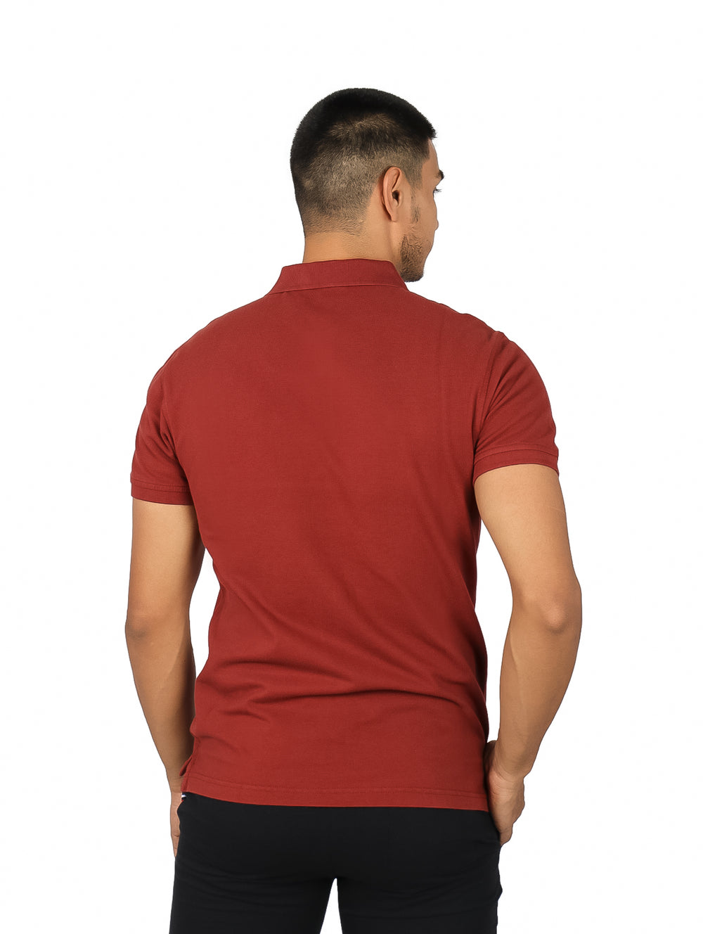 Hombre vistiendo una playera polo de color rojo ladrillo con cuello y botones.