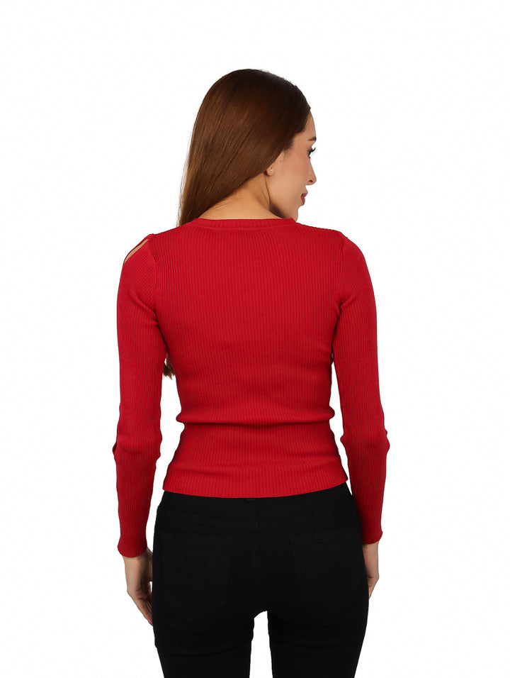 Mujer vistiendo un suéter rojo tejido con recortes en la manga y pantalones negros.