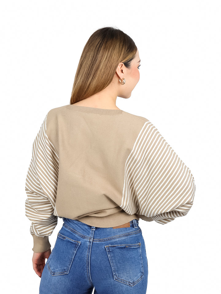 Mujer vistiendo un suéter color khaki con detalles de rayas blancas en las mangas y costados.