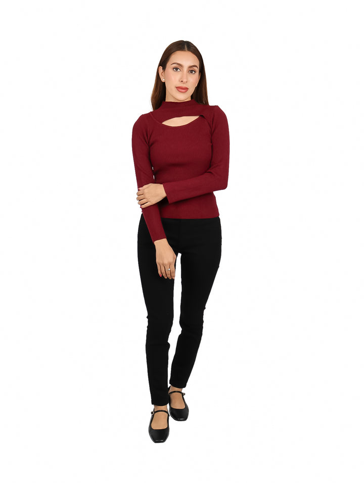 Mujer vistiendo un suéter color vino de manga larga con escote en el pecho y pantalones negros.
