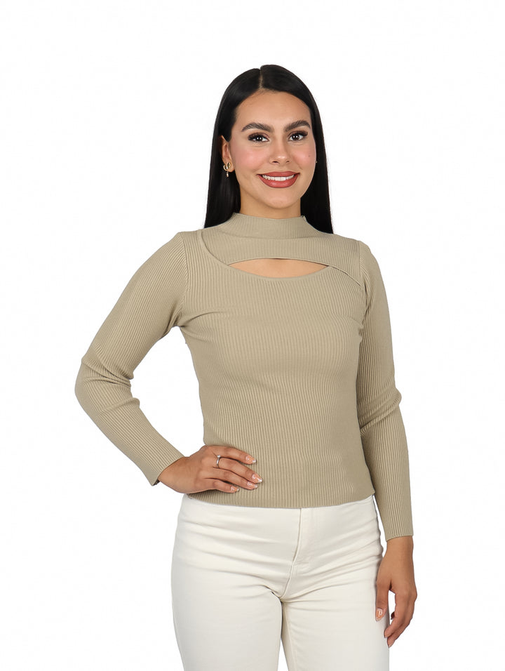 Mujer vistiendo suéter color camel de manga larga con escote en el pecho y pantalones blancos.