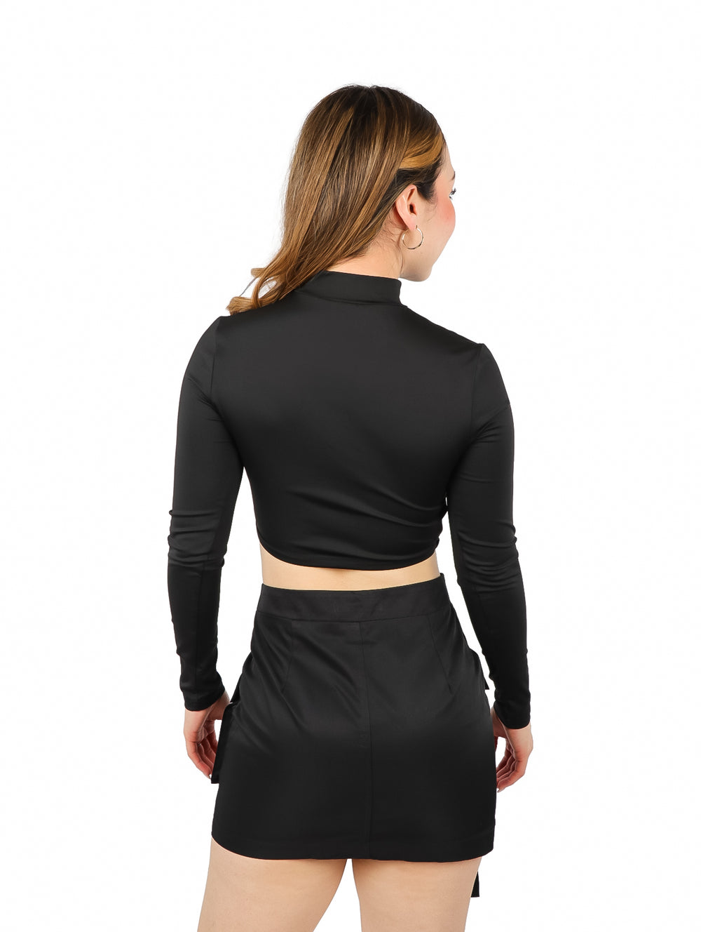 Blusa corta negra de manga larga con detalle transparente en la zona abdominal.