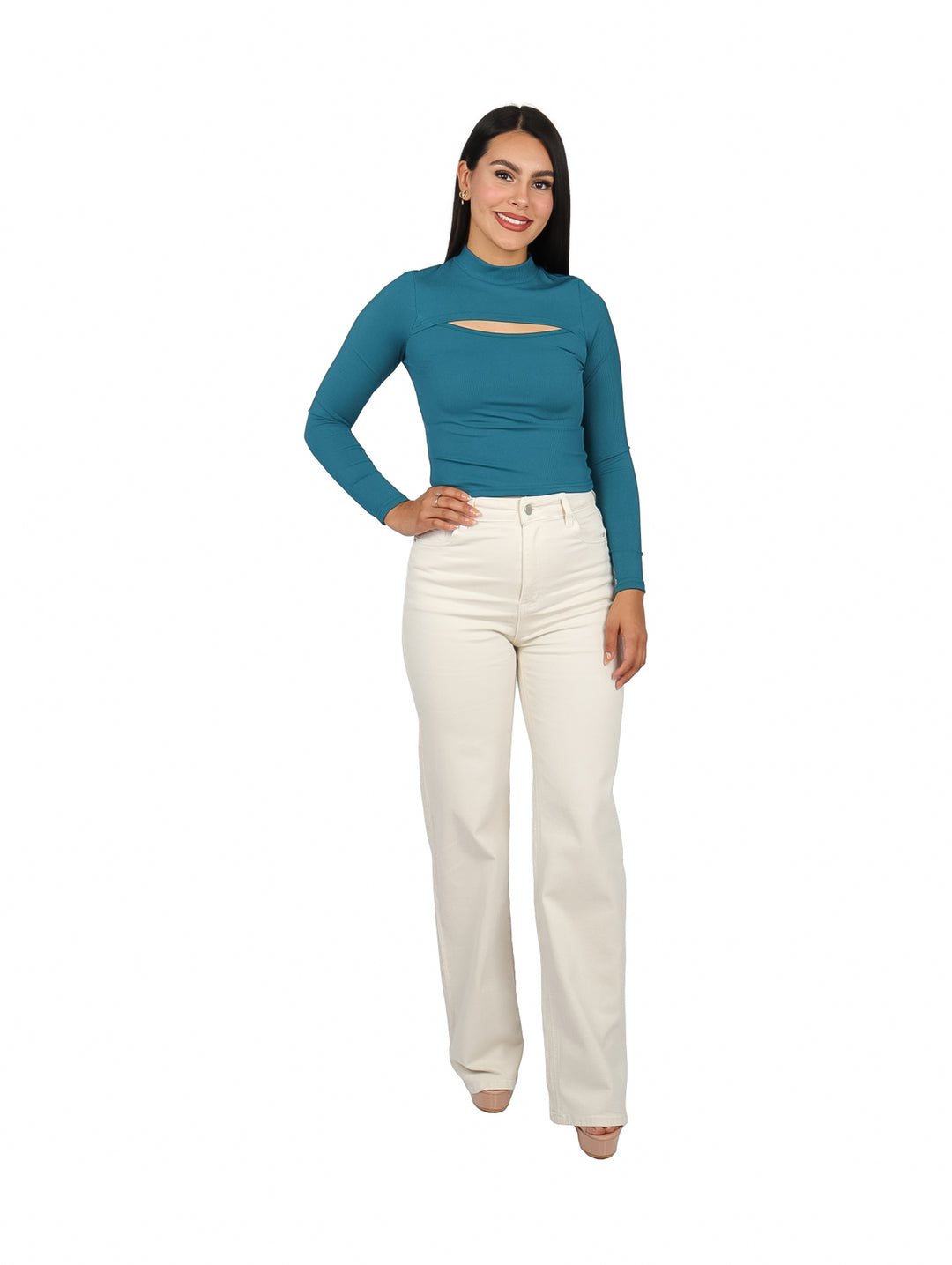 Mujer vistiendo blusa verde de manga larga con escote en el pecho y pantalones blancos.