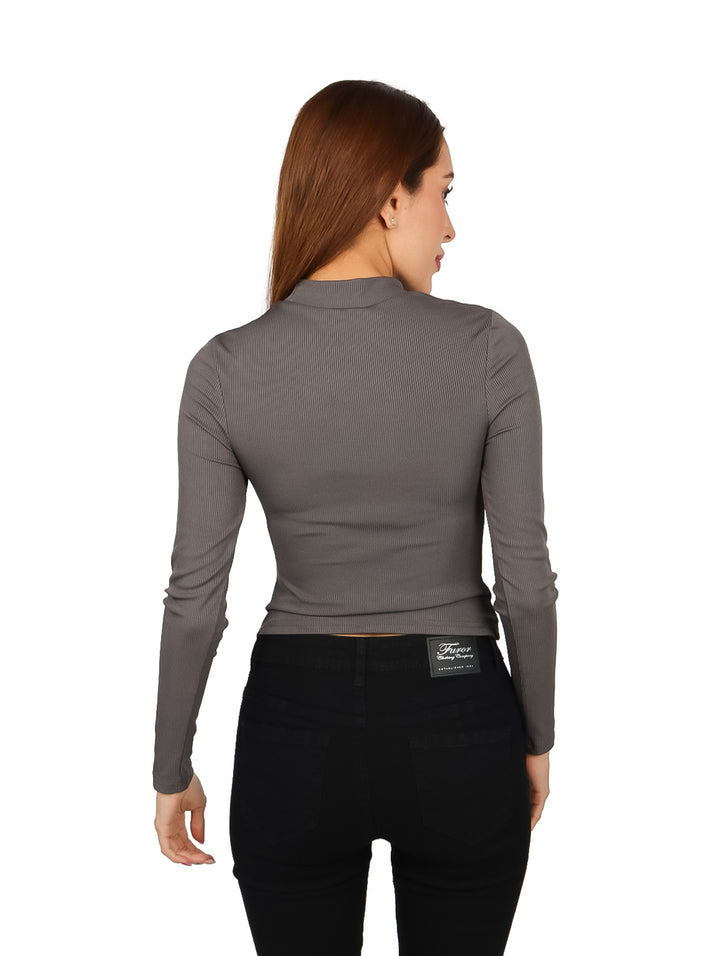 Mujer vistiendo blusa gris de manga larga con escote frontal y textura acanalada.