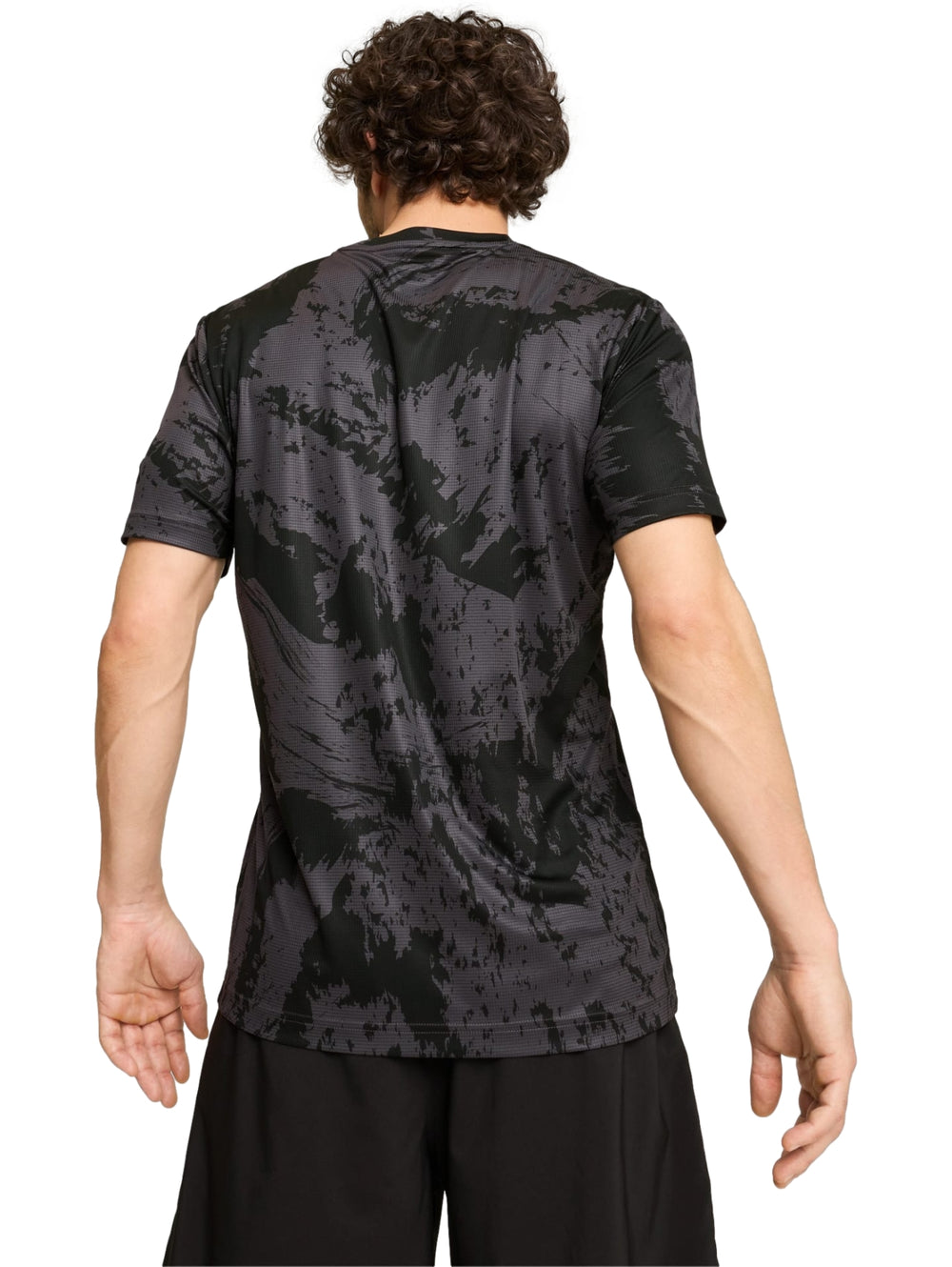 Camiseta deportiva PUMA color negro con estampado abstracto en gris y logotipo blanco en el pecho.