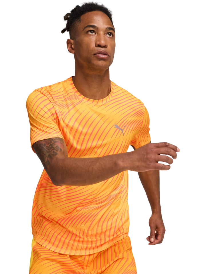 Hombre vistiendo playera deportiva PUMA color naranja con estampado de rayas diagonales.