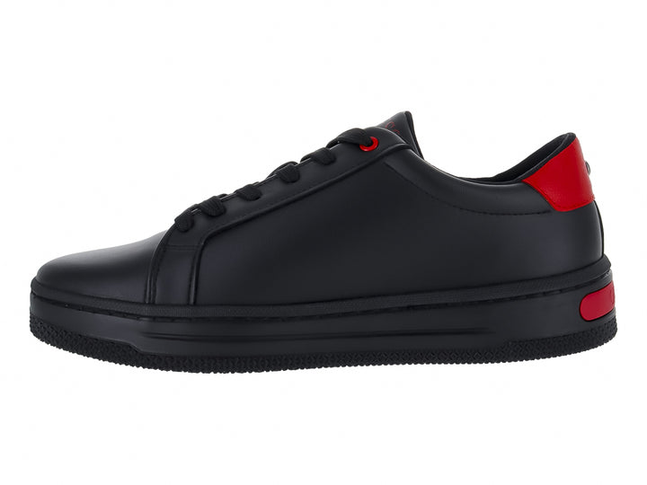 Tenis negros de la marca GUESS con detalles en color rojo y suela negra.