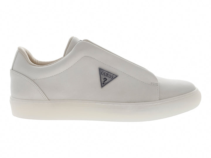 Tenis casuales color beige marca Guess, estilo slip-on con suela blanca y logo lateral.