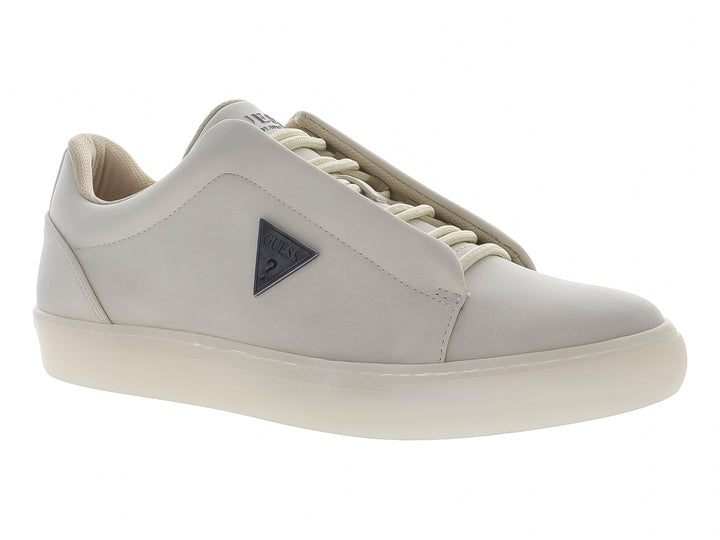 Tenis casuales color beige marca Guess, estilo slip-on con suela blanca y logo lateral.
