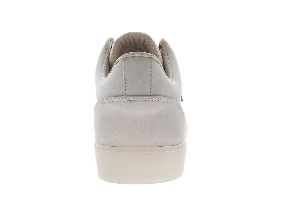 Tenis casuales color beige marca Guess, estilo slip-on con suela blanca y logo lateral.