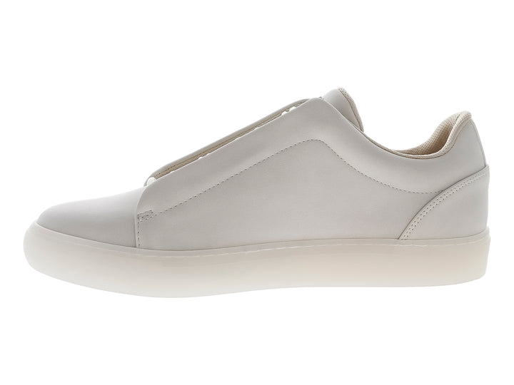 Tenis casuales color beige marca Guess, estilo slip-on con suela blanca y logo lateral.