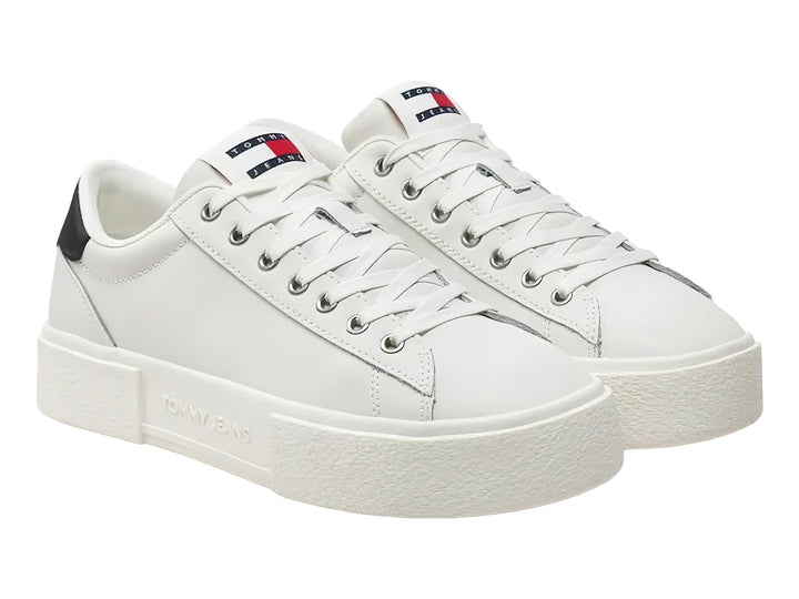 Tenis blancos de plataforma Tommy Hilfiger con detalle negro en el talón y suela ancha blanca.
