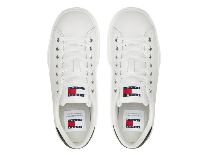 Tenis blancos de plataforma Tommy Hilfiger con detalle negro en el talón y suela ancha blanca.