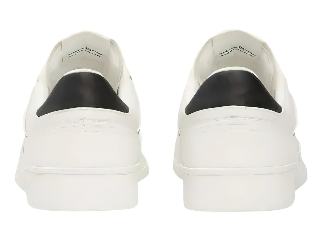 Tenis blancos de cuero Tommy Jeans con detalle negro en el talón y suela blanca.