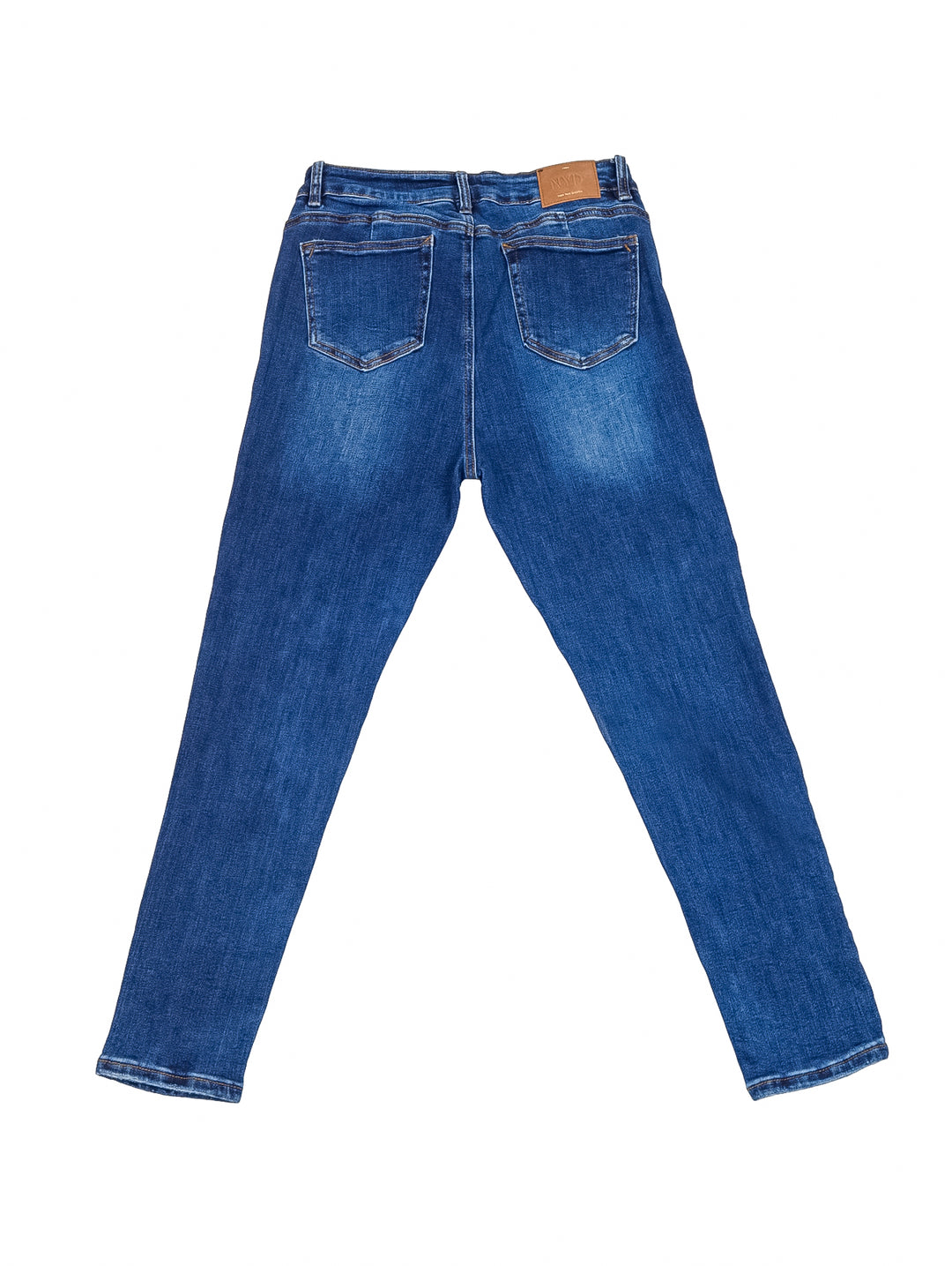 Mujer vistiendo pantalones jeans skinny en color azul oscuro con playera blanca y tenis blancos.